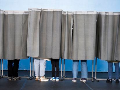 Varias personas ejercen su derecho al voto en el pabellón polideportivo Ames en A Coruña, este domingo.