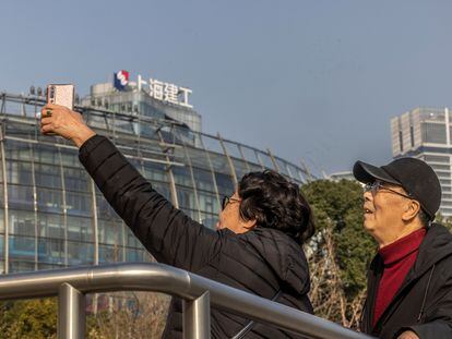 Dos personas se fotografían frente a un edificio de Evergrande en Shanghái.