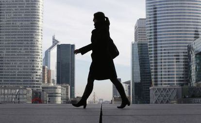 Un mujer pasa por el distrito financiero de La Défense, en París.