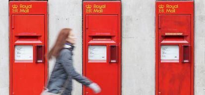 Una transeunte camina cerca de unos buzones en Londres