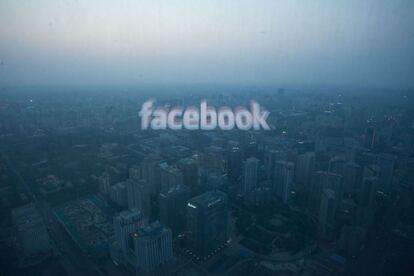 El logotipo de Facebook reflejado en una ventana del skyline de Beijing.