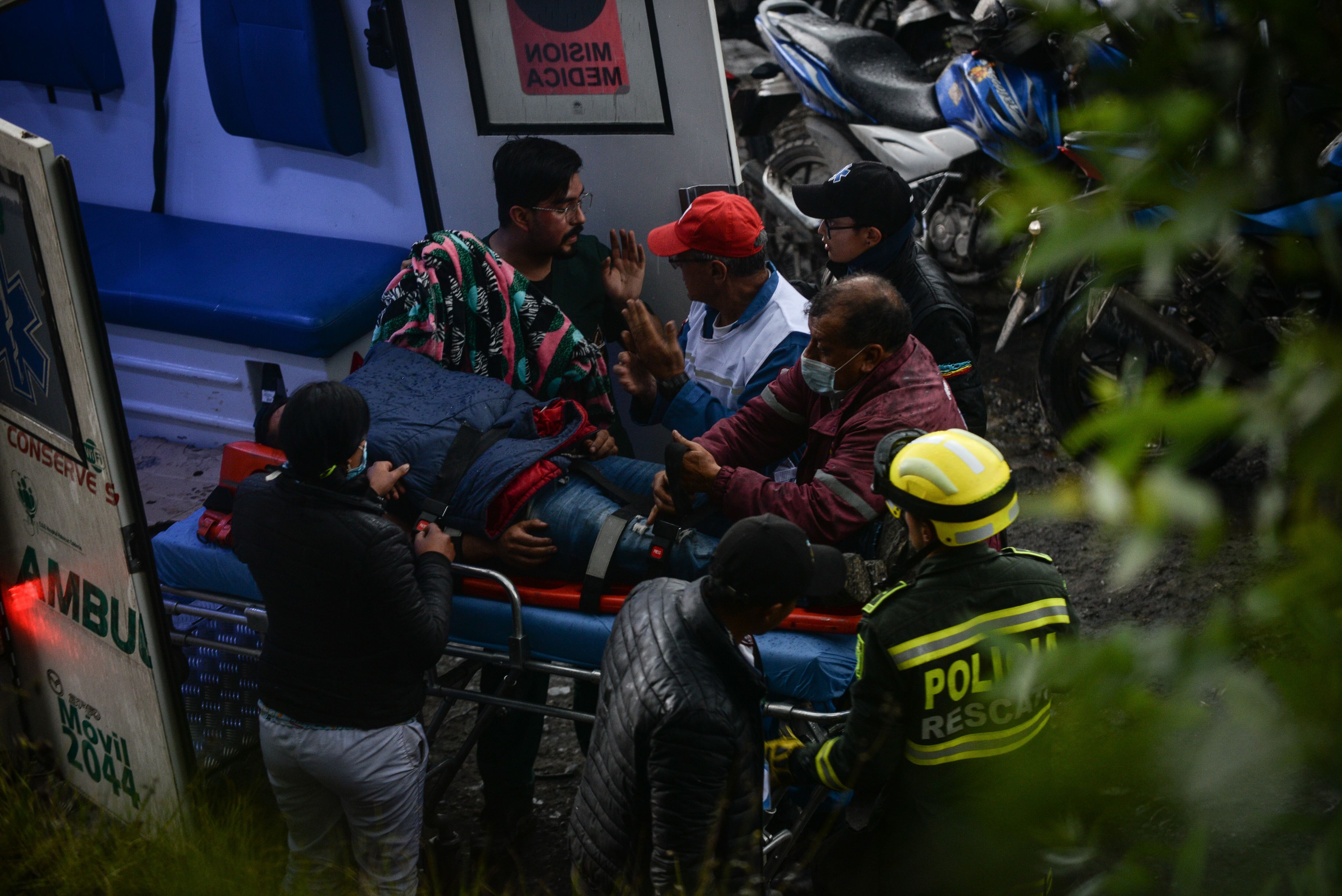 Un hombre que se encontraba cerca de la mina Los Chocos es llevado a una ambulancia para recibir primeros auxilios.