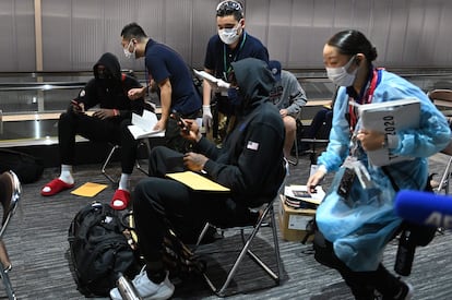 Jerami Grant (C) del equipo de baloncesto de Estados Unidos, durante el interminable papeleo en el aeropuerto de Narita.