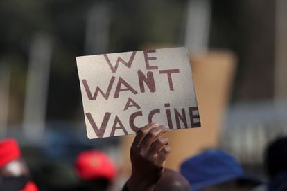 Una persona sostiene un cartel en una manifestación en la que se exigía acceso a las vacunas contra la covid-19, en Pretoria, Sudáfrica, en junio.