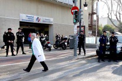 Un facultativo del Clínico cruza la calle custodiada por la policía.