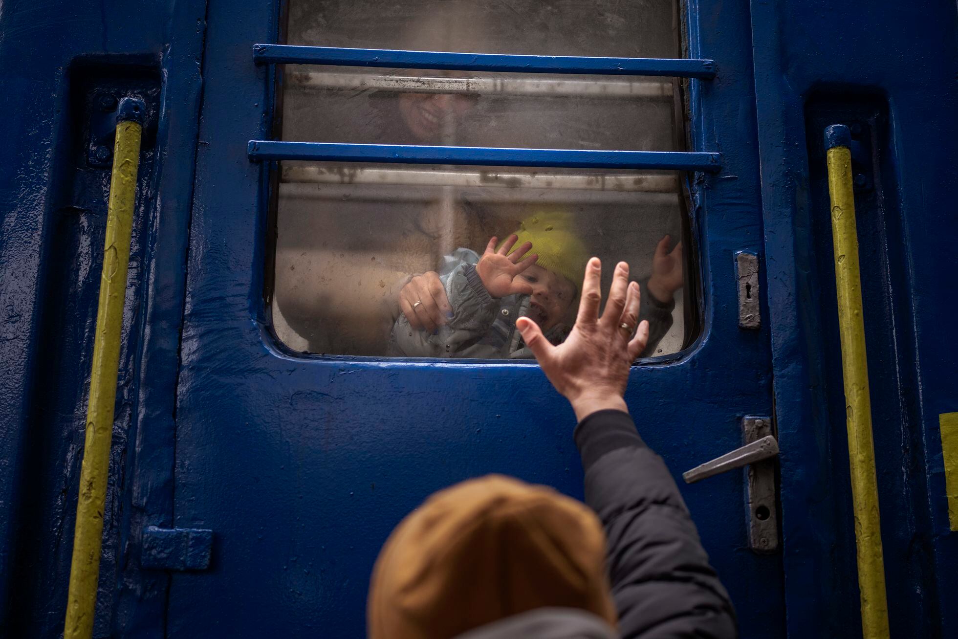 Un hombre se despide de su esposa e hijo, a punto de partir en un tren a Lviv desde la estación de Kiev, el pasado 3 de marzo. 