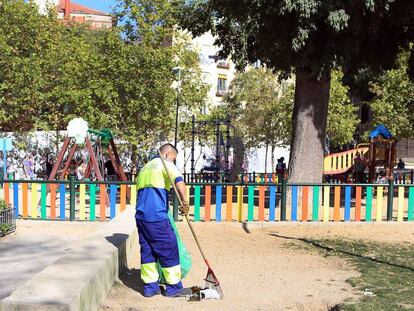 Un barrendero limpia, en 2014, en el parque del Casino de la Reina, en Lavapi&eacute;s.
