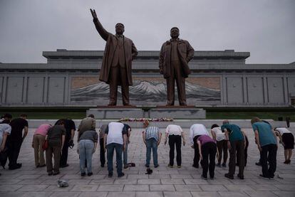 Un grupo de turistas se inclinan antes las estatuas de los líderes norcoreanos en la Colina Mansu en Pyongyang.