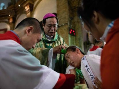 El obispo Joseph Li Shan bautiza a una mujer en la catedral de la Inmaculada Concepción, este sábado en Pekín.
