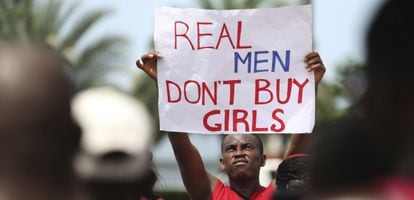 Un hombre sostiene un cartel donde se lee "los hombres de verdad no compran chicas" en una protesta en Lagos contra Boko Haram.