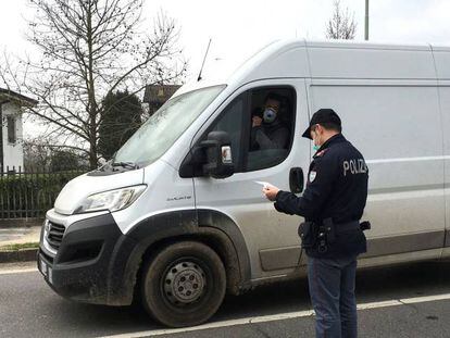  Dos operarios de la Policía Local italiana hacen guardia este martes en uno de los puestos de control para entrar en un municipio en cuarentena en la 