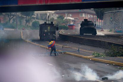 Los manifestantes respondieron con bombas molotov, cohetes de fuegos artificiales y piedras, como en esta fotografía, en la que un manifestante arroja una piedra hacia un vehículo de la policía ecuatoriana, en Quito, el 23 de junio de 2022. 