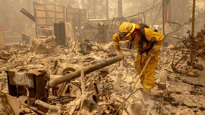 Un bombero busca entre los restos de una casa quemada en Berry Creek, California.