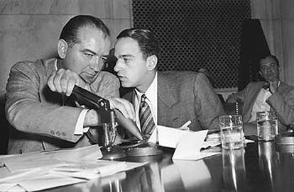 El senador Joseph McCarthy tapa el micrófono para consultar a su asesor legal, Roy Cohn, durante una de las sesiones públicas celebradas en abril de 1954.