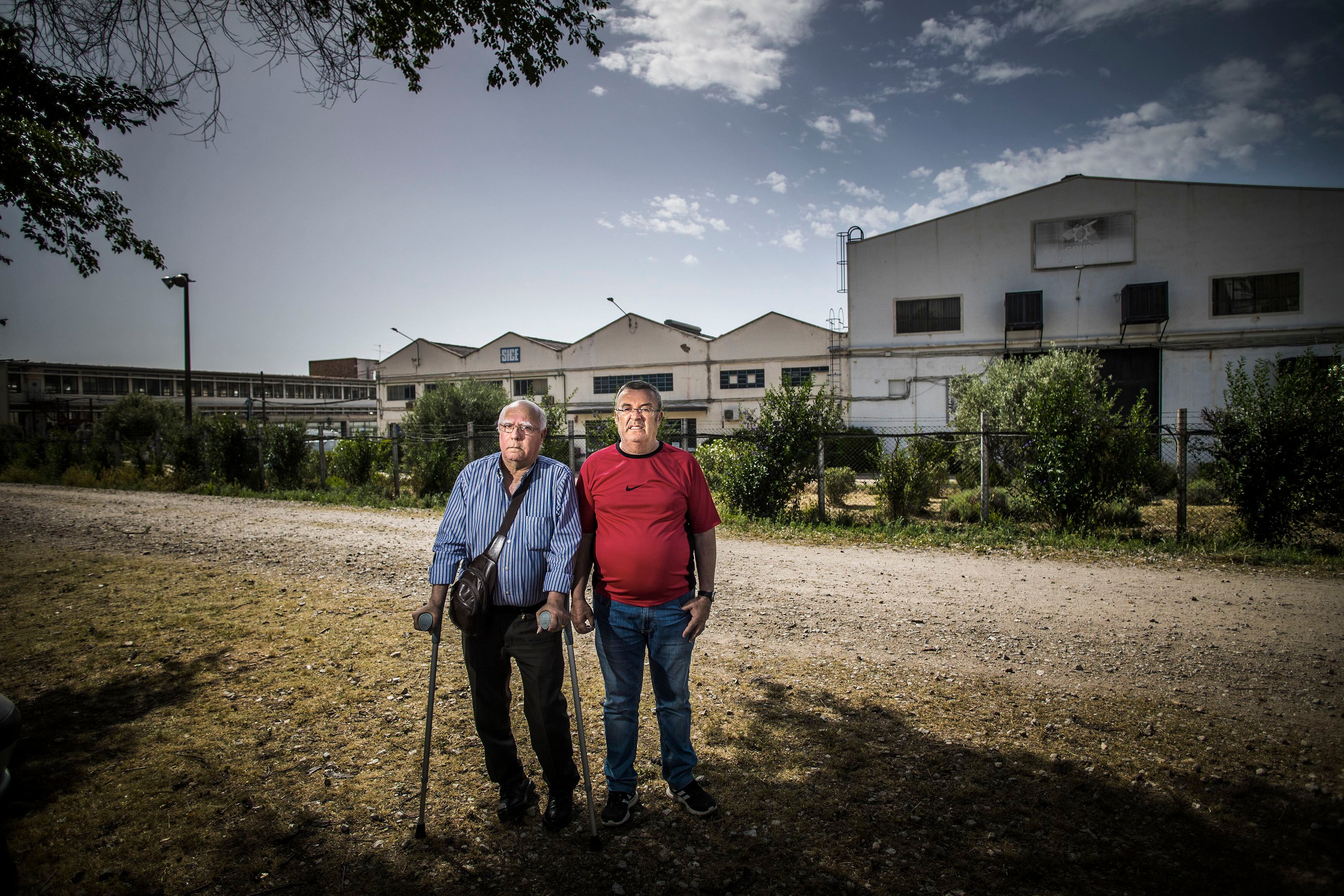 Pepe y Juan José, dos antiguos empleados de Santana Motor, junto a la puerta de la antigua factoría en Linares (Jaén). 