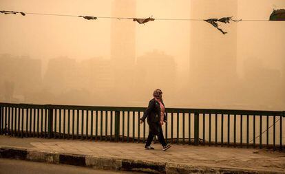 Varias personas caminan por las calles de El Cairo (Egipto) durante una tormenta de arena que ha cubierto parte de Oriente Medio.