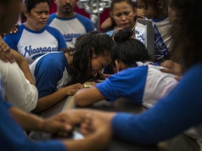 Amigos de Gerald Vázquez lloran sobre su ataúd durante su funeral.