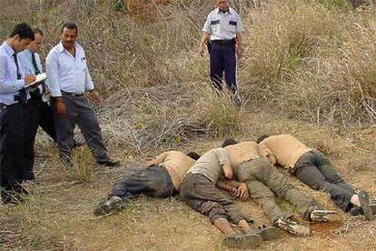 Agentes de policía examinan los cadáveres de los tres hermanos Faddoul y del chófer de la familia.