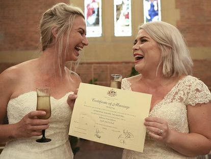 Sarah Turnbull (izquierda) y Rebecca Hickson (derecha) con su certificado de matrimonio después de casarse el lunes en Newcastle (Australia).