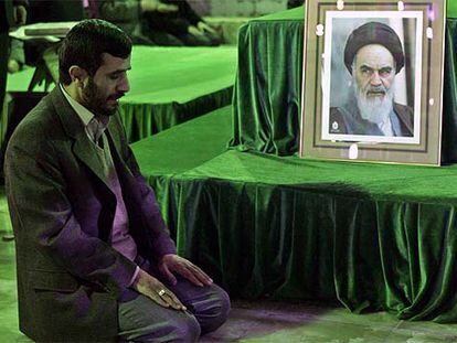 El presidente iraní, Mahmud Ahmadineyad, reza ante un retrato del ayatolá Jomeini, ayer en Teherán.