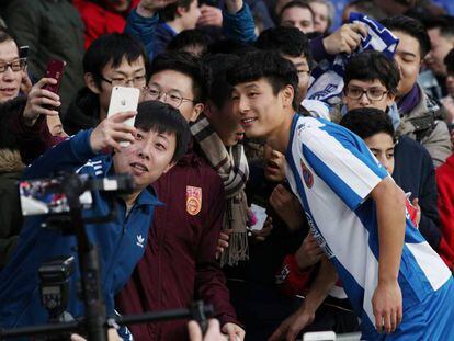 Wu Lei, del Espanyol, posa con aficionados en Barcelona.  