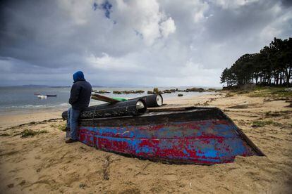 Un furtivo de la ría de Arousa junto a una embarcación utilizada por mariscadores ilegales.