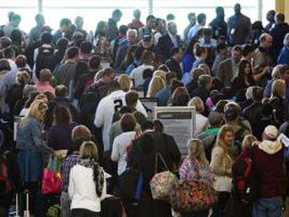 Varios pasajeros fueron registrados este viernes al  esperar en línea en el aeropuerto de Arlington, Virginia (EE.UU.), afectados por los retrasos en cientos de vuelos como consecuencia de las medidas de recorte del gasto que comenzaron a ser aplicadas esta semana.