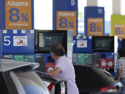 Dos personas repostan en una gasolinera de Madrid.
