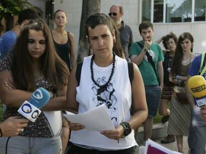 Dos jóvenes multadas por la huelga contra la Ley Wert leen un manifiesto.