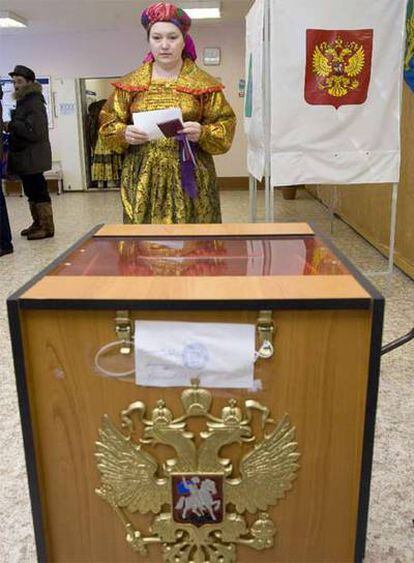 Una mujer ataviada con el vestido típico komi enfrente de una urna en Kharsaim, a unos 2.000 Km al noreste de Moscú