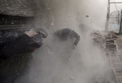 Miembros del Ejército Libre de Siria se protege del fuego enemigo durante un combate por las calles de Damasco.