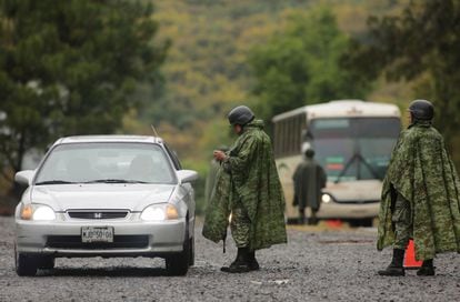 Miembros de la Guardia Nacional revisan vehículos en un renten militar en la zona de Uruapan, Michoacán.  