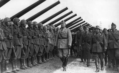 Mussolini pasa revista a una unidad de artillería en Italia.