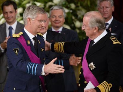 Alberto II y su hijo Felipe se abrazan durante el acto de abdicación.