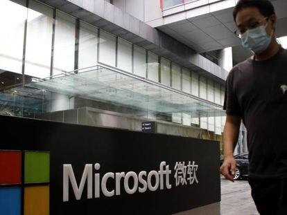 Un hombre pasa junto al logo de las oficinas de Microsoft en Pekín.