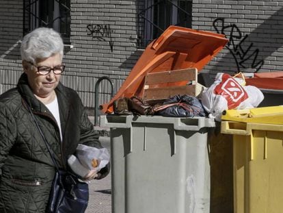 Una mujer pasa ante un cubo de basura este martes. 