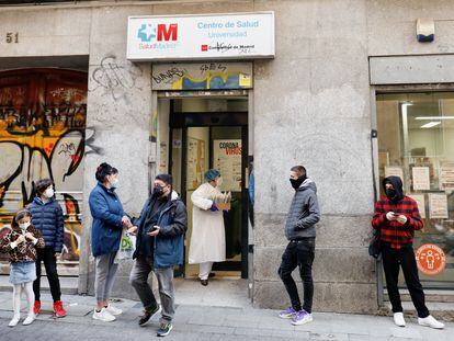 Varias personas esperan en la puerta de un centro de salud de Madrid, el 21 de diciembre.