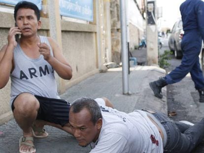 Dos personas se resguardan en el momento de los atentados