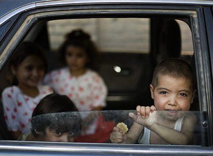 Niños miran por la ventana de un coche en Herat.