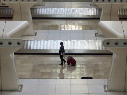 Un pasajero recogiendo su maleta en el aeropuerto de Madrid vacío