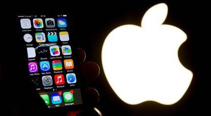 Un iPhone junto al logo de Apple. 