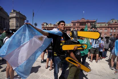 Supporters of Javier Milei carry figures of chainsaws as they wait in front of the official residence in Buenos Aires.