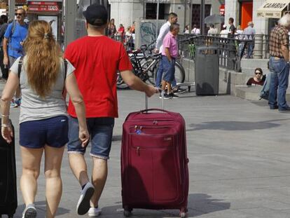 Turistas con maletas en el centro de Madrid.