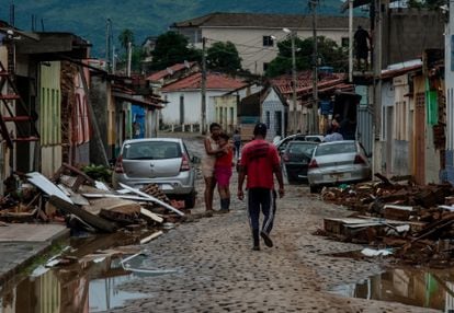 AME6380.  ITAMBÉ (BRAZIL), 12/27/2021.- People observe their houses destroyed by floods caused by rains today, in the city of Itambé, in the state of Bahia (Brazil).  The heavy rains that have hit northeastern Brazil since the end of November have left at least 18 dead, 286 injured and 2 missing, in addition to some 16,000 victims, only in the state of Bahia, according to the report this Monday from regional authorities.  EFE / Felipe Iruatã
