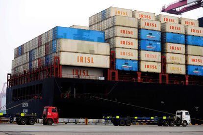 Varios camiones transportan contenedores en el puerto de Qingdao, en la provincia china de Shandong.