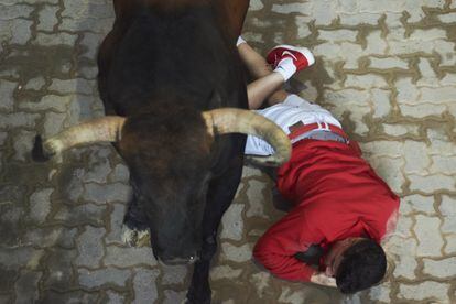 Un mozo permanece en el suelo al paso de uno de los toros de la ganadería de Nuñéz del Cuvillo, este viernes.