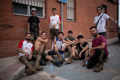 Un grupo de jóvenes de entre 18 y 20 años descansa frente al centro polivalente de la localidad después de ayudar a limpiar las calles de barro.