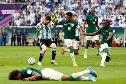  Lionel Messi (i) de Argentina disputa el balón con Salem Aldawsari de Arabia Saudita (c) frente al jugador lesionado Yasser Alshahrani (abajo) hoy, en un partido de la fase de grupos del Mundial de Fútbol Qatar 2022 entre Argentina y Arabia Saudita en el estadio de Lusail (Catar).