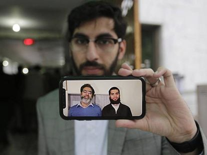 Un hombre muestra una fotografía de Naeem Rashid y su hijo Talha Naeem, dos de los nueve paquistaníes asesinados en el atentado de Christchurch, este lunes en Lahore (Pakistán).