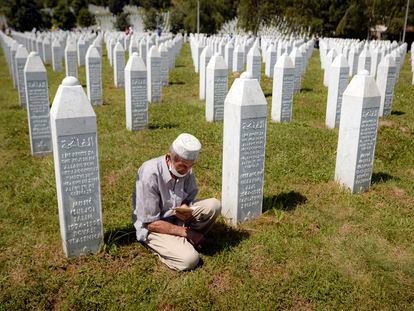 Un hombre reza entre lápidas en Potocari, cerca de Srebrenica (Bosnia), en julio de 2020, durante el 25º aniversario de la matanza de 8.000 musulmanes.